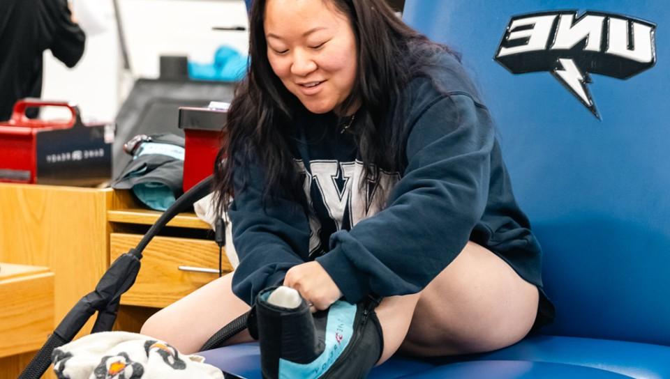 一名运动训练的学生在课堂上练习给脚部受伤的人冰敷